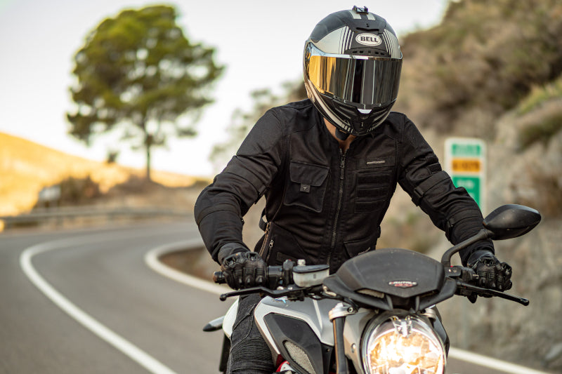 motocyklista jedzie górską drogą w kasku z lustrzaną szybą
