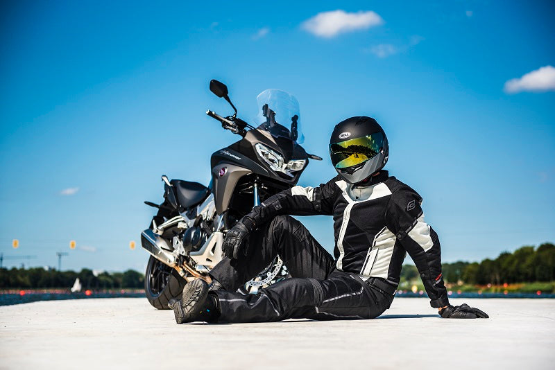 motocyklista siedzi na betonie przed swoim motocyklem