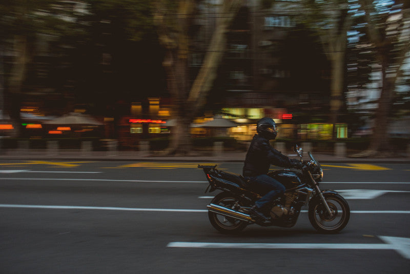 motocyklista na drodze w kurtce miejskiej 