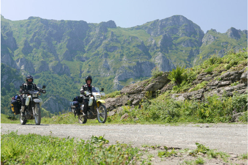 dwóch motocyklistów na trasie z widokiem na góry 