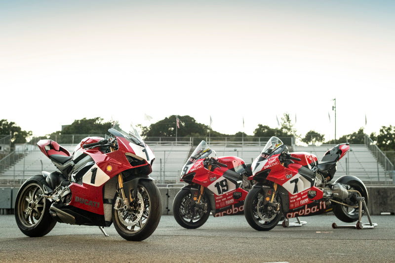 3 motocykle sportowe Ducati stoją na poboczu toru 