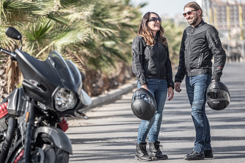 Dwójka motocyklistów stoi przy motorze