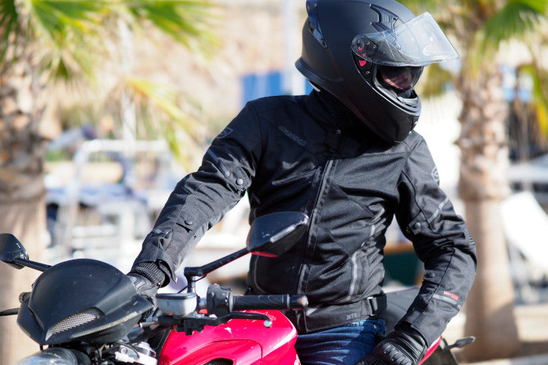 lato, motocyklista siedzi na czerwonym motocyklu, jest ubrany w czarną kurtkę ozone jet ii