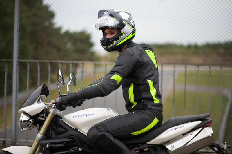 Motocyklista ubrany w kombinezon Ozone Volt siedzi na motocyklu
