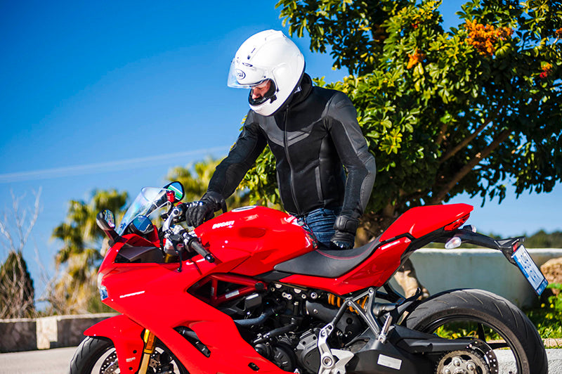 motocyklista wkłada kluczyki w stacyjkę swojego ducati