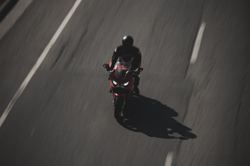 Motocyklista na drodze na czerwonym motocyklu