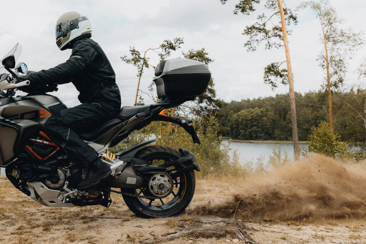 motocyklista jedzie na motorze po drodze gruntownej