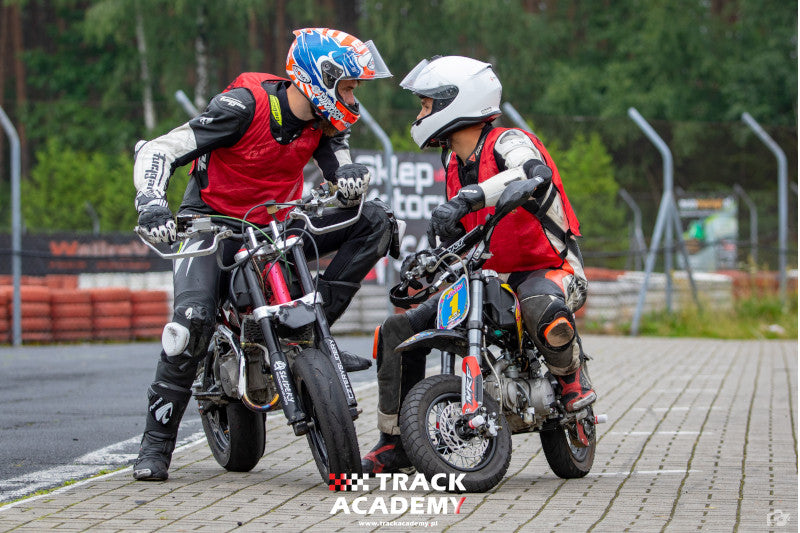 dwóch motocyklistów w czasie szkolenia motocyklowe Track Academy stoi na motocyklach i patrzy w oczy