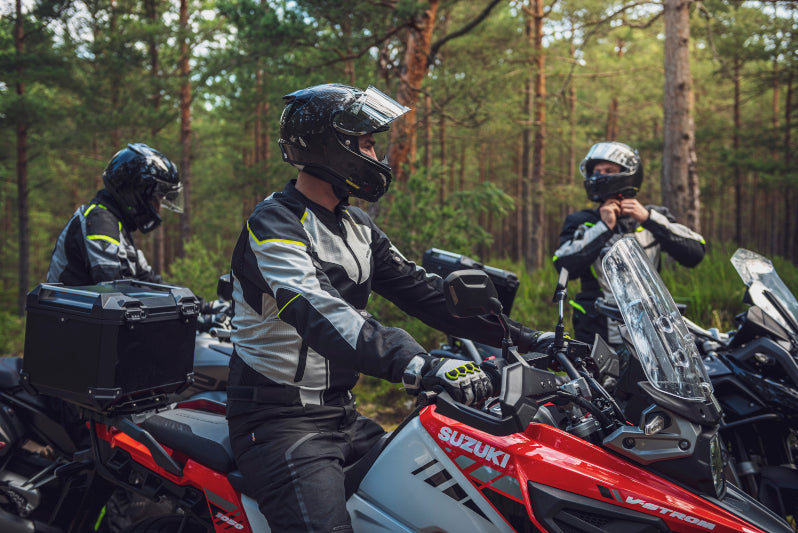 trójka motocyklowych turystów podczas postoju w lesie